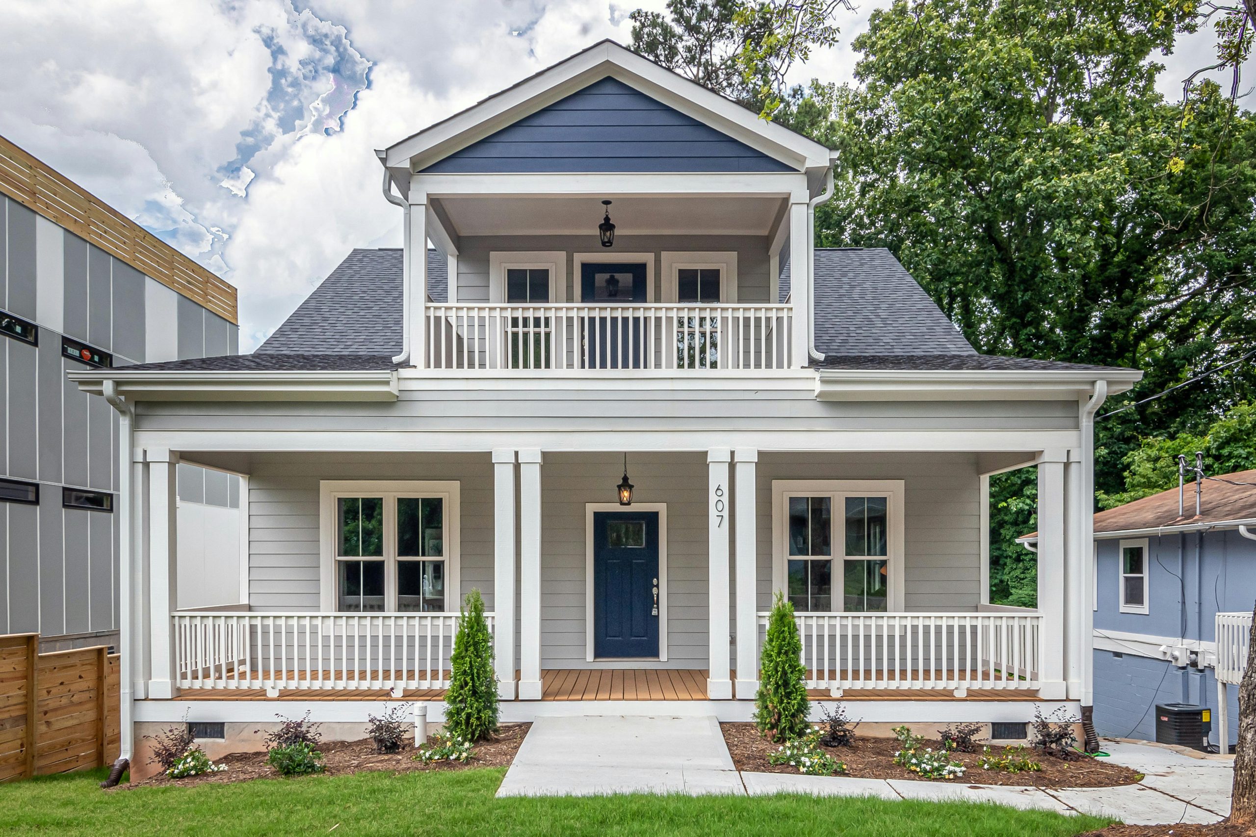 White and brown wooden house with balcony over a porch